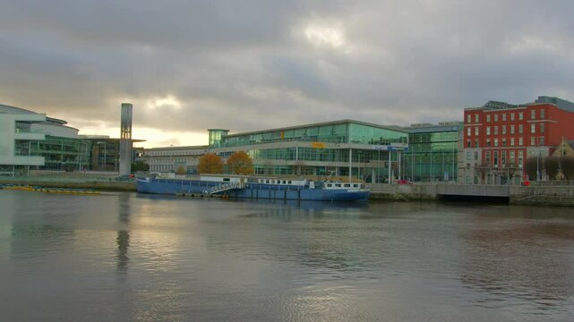 Right to left camera shot of the Waterfront area in Belfast, Northern Ireland. Filmed on an autumn day with the River Lagan in the foreground. Filmed in 4K, 25FPS and in Rec709 color space.