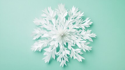 Fototapeta premium Intricate white paper flakes arranged in a symmetrical pattern, isolated on a soft mint green background