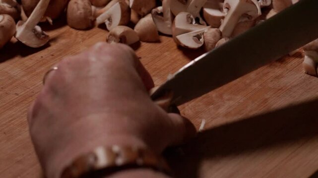 vid&eacute;o en slow motion, d'une main de femme, coupant des champignon de Paris