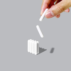A minimalistic image showcasing magnetic stirrer bars used for laboratory applications. A hand is carefully placing one stir bar, emphasizing precision and scientific equipment.