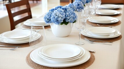 Beautifully set dining table with blue hydrangea flowers and white tableware.