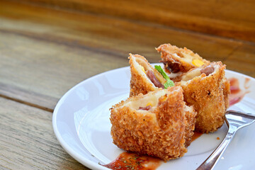 Close up view of mayo risoles with fork on the white plate. Copy space, empty space, free space on the left side.