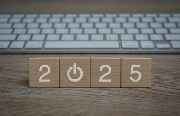 2025 start up business icon on wood block cubes on wooden table with modern computer keyboard,...