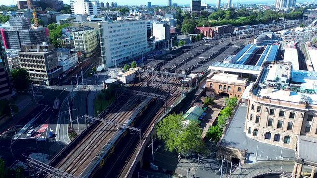 Drone aerial landscape of commuter train on railway tracks line entering Sydney's Central station yard platform city Australia transport urban travel tourism