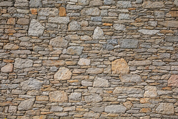 Vieux mur de pierres seiches d'une ancienne maison.