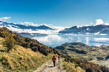 Fototapeta premium Group of hiker hiking on Roys Peak track with landscape of foggy mountain and lake in New Zealand
