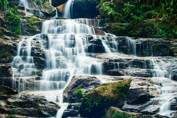Waterfall cascading over rocky terrain in tropical forest at Vietnam