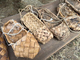 A collection of woven baskets and shoes sit on a wooden table