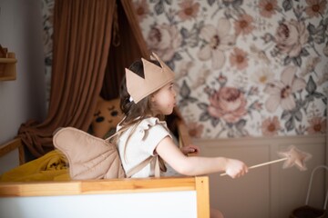 little girl in a fairy-tale children's room sitting on the bed