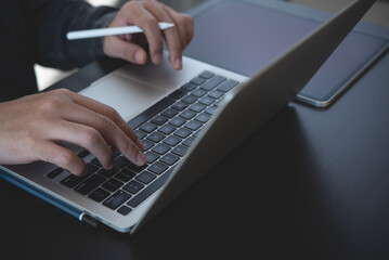 Man hands typing on laptop computer keyboard and surfing the internet on office table, online working, business and technology, internet network communication concept, close up
