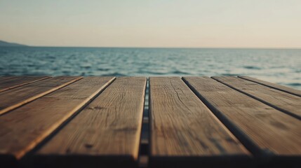 Fototapeta premium Wooden table set against a backdrop of the sea, creating a serene atmosphere. The empty wooden table invites contemplation, perfect for relaxing moments by the sea.