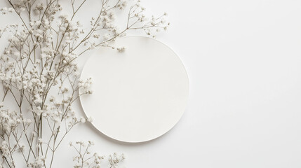 Minimalist design featuring white flowers on a round plate against a clean white background conveys simplicity and elegance.