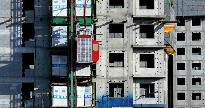 Construction site, in progress. Unfinished building and Elevator is moving