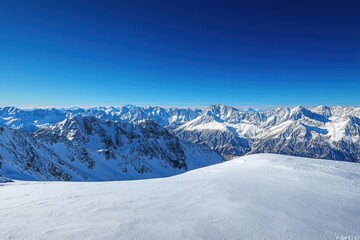 A panoramic view of snow-covered mountains under a clear blue sky.