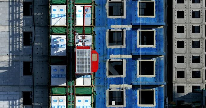 Construction site, in progress. Unfinished building and Elevator is moving