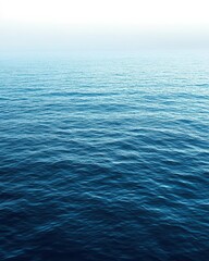 Obraz premium Serene ocean surface with gentle waves and a calm atmosphere.