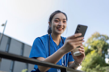Young Asian Female Nurse Enjoying a Break Outdoors with Phone