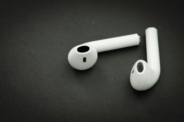 White wireless headphones on black table.