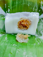 Steamed flour with coconut filling wrapped with banana leaf, Kanom sai sai.