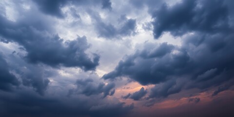 A majestic, dramatic sky with a soft glow of light breaking through the dense, grey clouds.