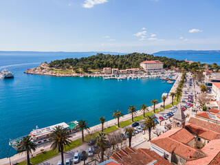 Aerial view of Makarska city center with its vibrant waterfront, yachts, traditional architecture, and the stunning Adriatic Sea coastline