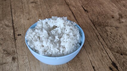 Rice in a blue bowl on a wooden table