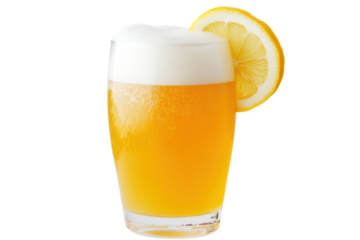 A refreshing glass of wheat beer with a cloudy appearance, topped with a thick, frothy white head. The glass is adorned with a slice of lemon on the rim, creating a vibrant and inviting look.