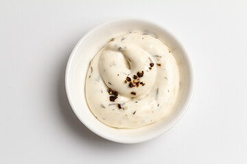 White bowl with cheese sauce on the white background.