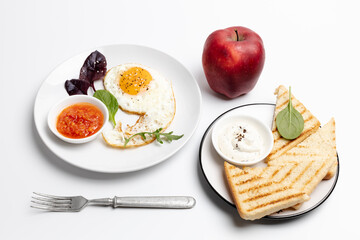 Fried egg on the plate, grilled toasts and an apple,