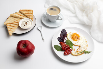 Fried egg on the plate, toasts with sauce and a cup of coffee.