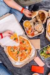 Hands taking slices of pizza close view. Friends eating pizza at the beach. Fast food concept. Beach holiday and summer vacation concept.