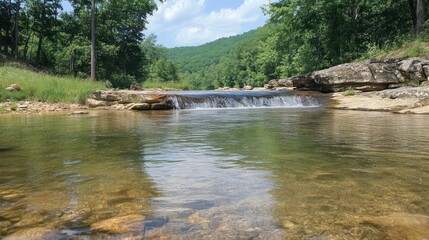 Serene forest stream cascades over rocks into a clear pool