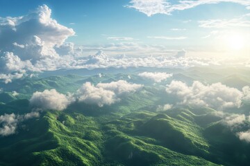 Aerial view of lush green mountains under a bright sky with clouds.