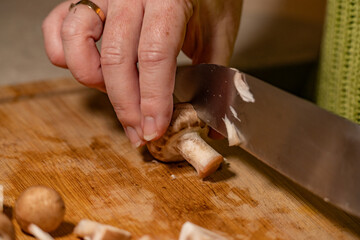 action de découpe d'un champignon de Paris avec un couteau chef, en gros plan