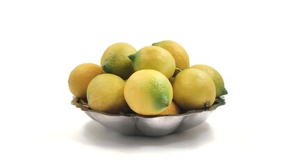 Photo of a bowl of fresh lemons in a decorative silver dish, isolated on a white background, showcasing vibrant yellow and green hues, ideal for culinary or kitchen decor inspiration.