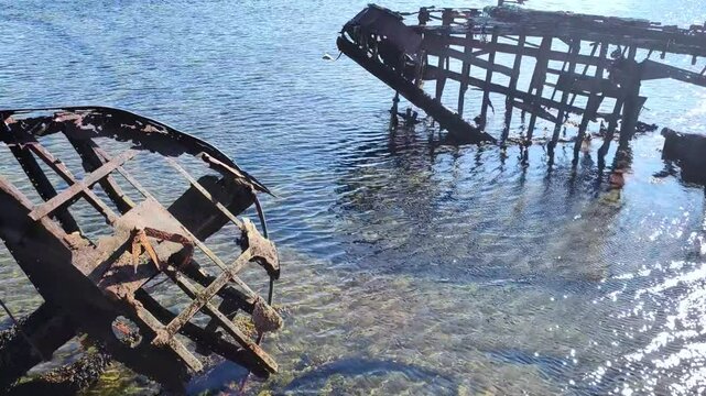 Cemetery of old ships Teriberka Murmansk Russia, wooden remains of industrial fishing boats in sea.