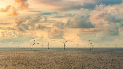 Tall windmill turbines against a clear blue sky, generating renewable energy in the serene Go Cong, Vietnam landscape by the sea. Like windmill park Westermeerdijk in the Noordoostpolder Netherlands.