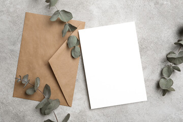Wedding invitation or blank greeting card mockup with envelope and eucalyptus twigs, top view © nikavera