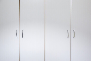 Closeup of doors of a white wardrobe.