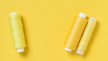 Yellow thread spools background with copy space for text close-up flat lay top view