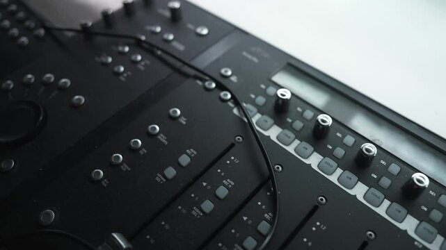 Detailed view of faders and knobs on an audio mixing console, showcasing the precision and complexity of sound engineering in a Los Angeles studio.