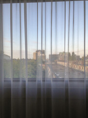 city through curtain of hotel room