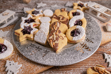 Variation of homemade christmas cookies. Traditional german egg yolk cookies on a silver plate on wooden table