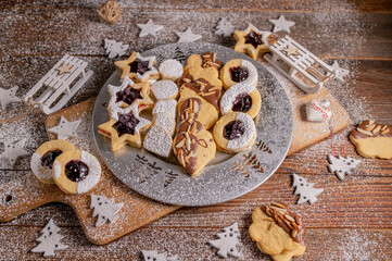 Variation of homemade christmas cookies. Traditional german egg yolk cookies on a silver plate on wooden table