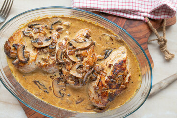 Baked chicken breast with delicious mushroom cream sauce in a baking dish on kitchen counter