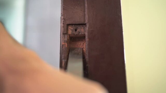Using a gouge to carve wooden door frame