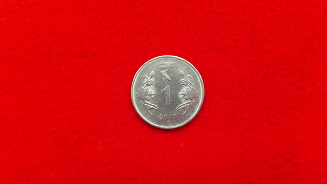 Different indian round metal rupee coin isolated on red background with copy space. Extreme closeup macro top view. Economy, trade, recession, inflation, savings and forex concept.