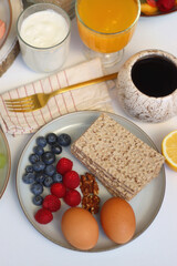 Assortment of various breakfast foods and drinks on the white table. Selective focus.