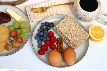 Assortment of various breakfast foods and drinks on the white table. Selective focus.
