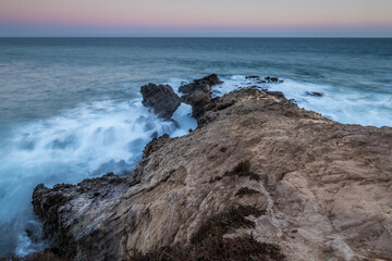Waves crashing against rocky cliffs in Malibu